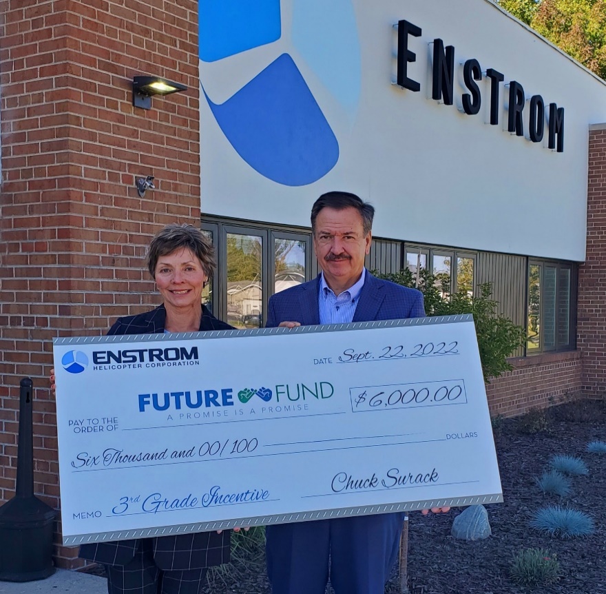 Chuck Surack presents a check from Enstrom